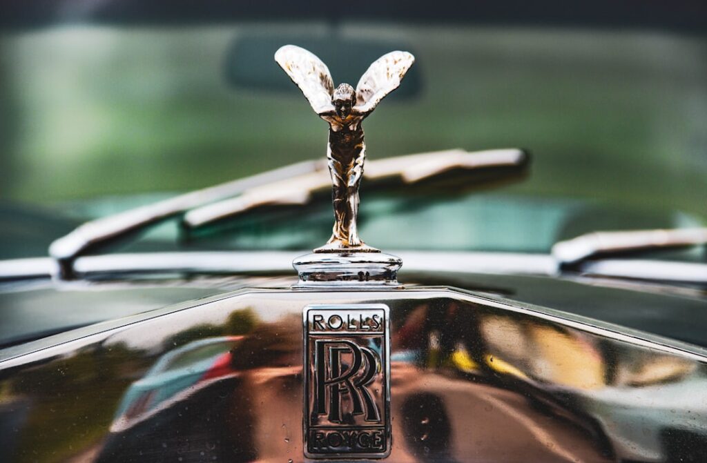 Close-up of the iconic Spirit of Ecstasy mascot and Rolls Royce badge on a classic bonnet