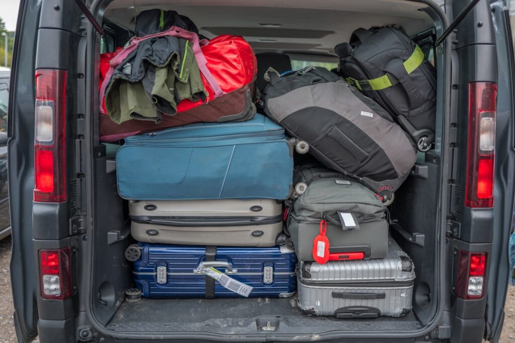Suitcases and travel bags packed into the boot of a minibus transfer vehicle